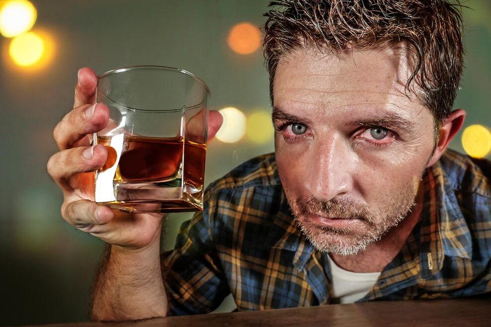 E Mann Alkoholiker kuckt schmerzhaf